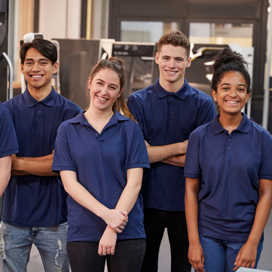 A group of people standing in 2 lines with smiles on their faces.