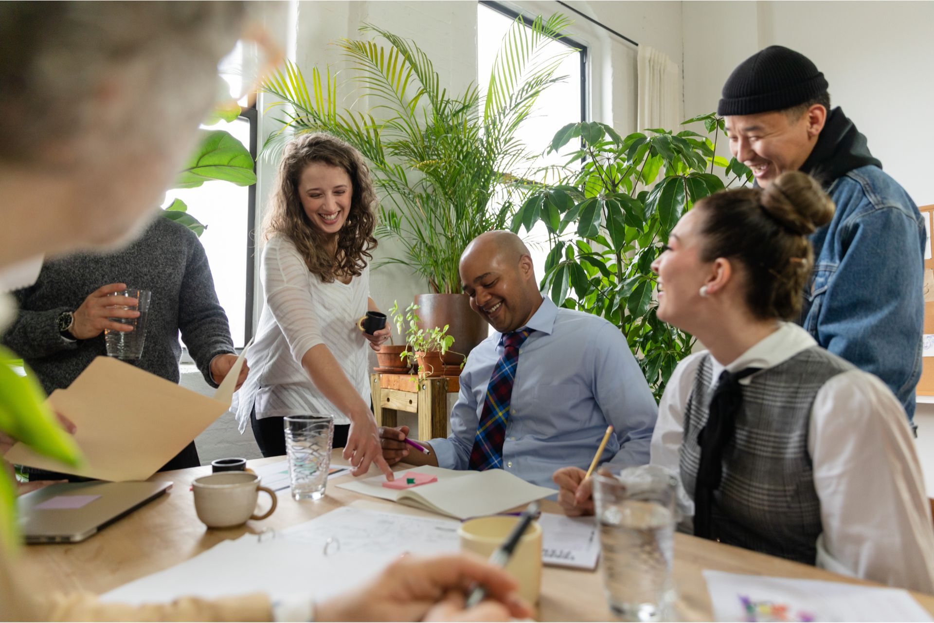 A group of indivduals that have gathered round a desk in order to resemble a bunch of workers.